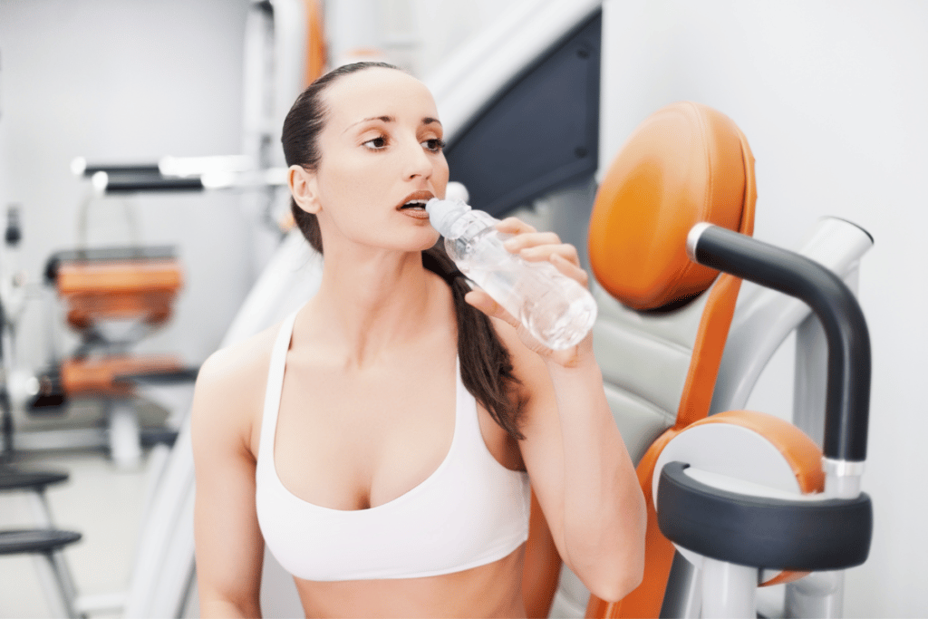 woman drinking water in the gym