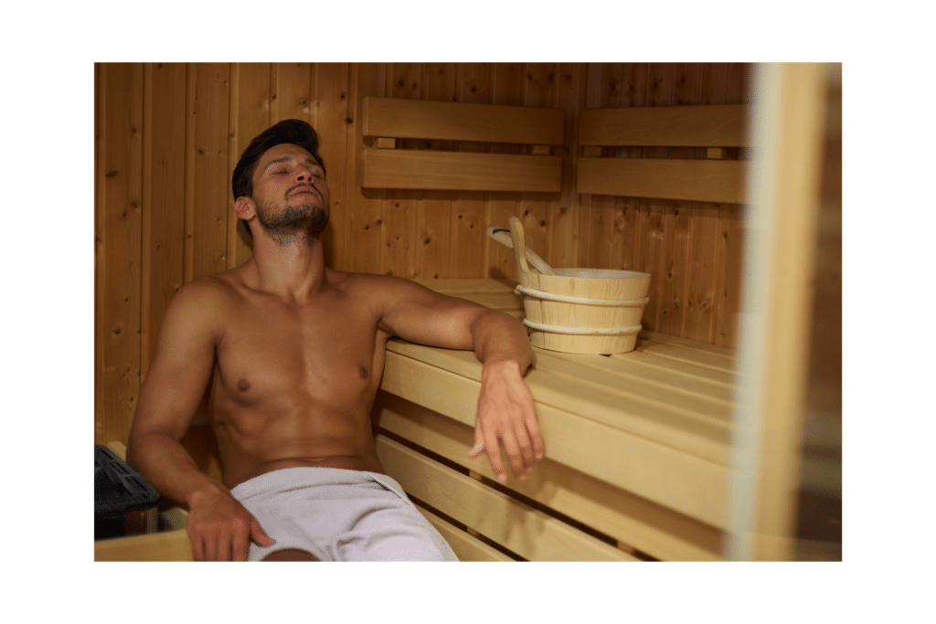 Tired man sweating in sauna with arm rested describing how hot is too hot in the sauna