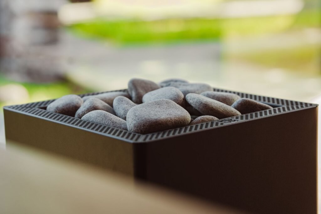 Modern electric sauna heater filled with smooth sauna stones