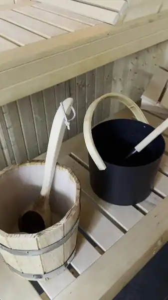 Sauna bucket and ladle on the bench of our basement sauna